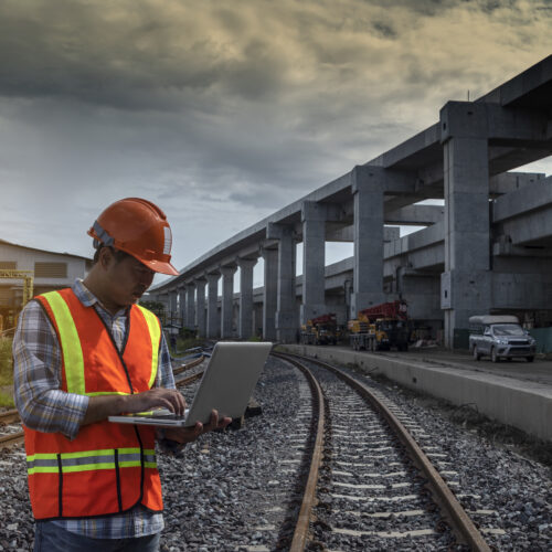 Senior engineer looking drawing on site construction of mass transits